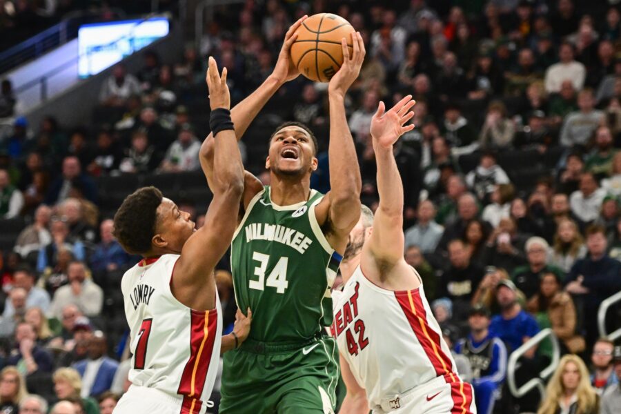 Oct 30, 2023; Milwaukee, Wisconsin, USA; Milwaukee Bucks forward Giannis Antetokounmpo (34) takes a shot between Miami Heat guard Kyle Lowry (7) and forward Kevin Love (42) in the first quarter at Fiserv Forum. Mandatory Credit: Benny Sieu-USA TODAY Sports