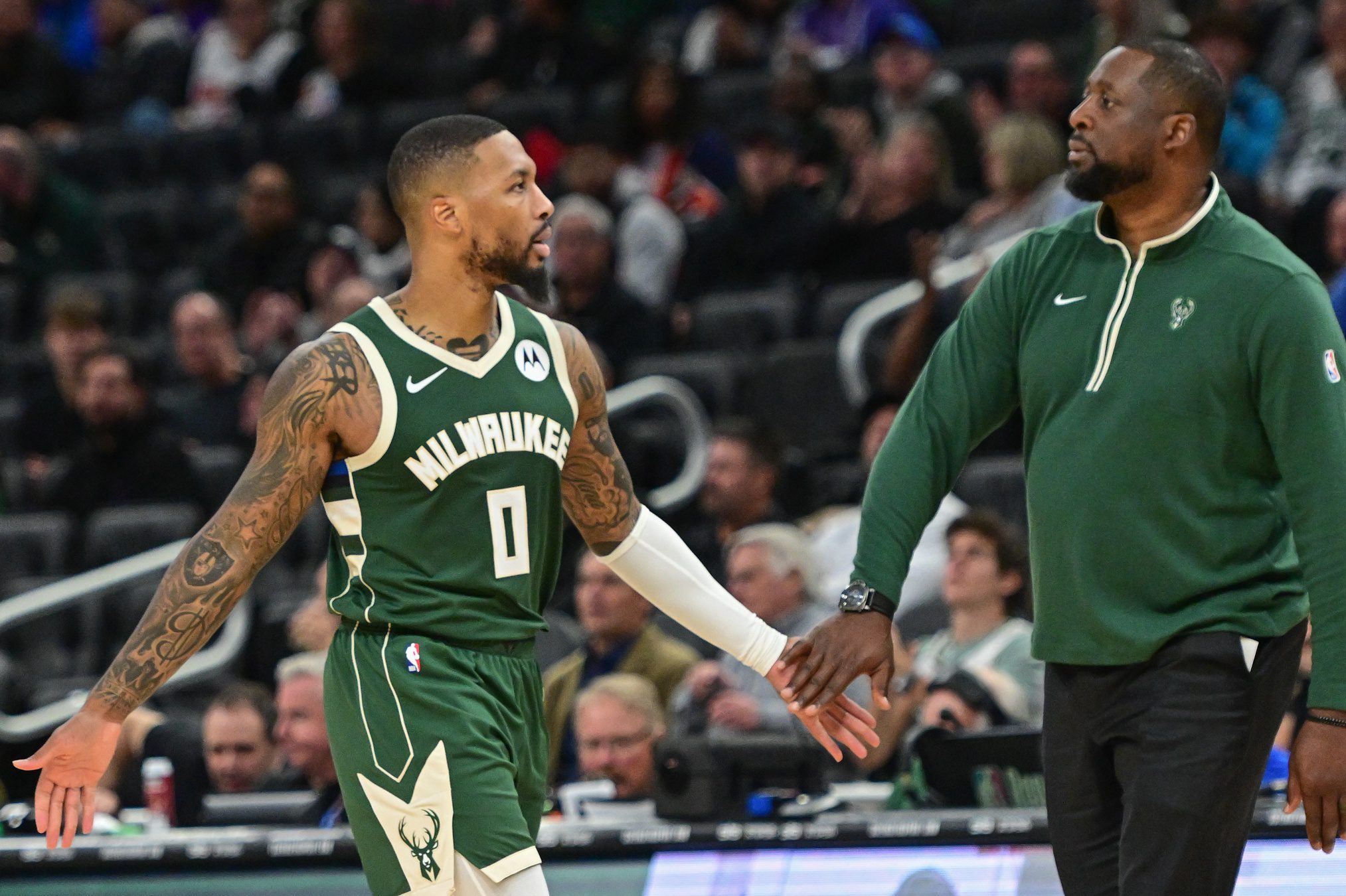 Oct 30, 2023; Milwaukee, Wisconsin, USA; Milwaukee Bucks head coach Adrian Griffin greets guard Damian Lillard (0) during a timeout in the third quarter against the Miami Heat at Fiserv Forum. Mandatory Credit: Benny Sieu-USA TODAY Sports