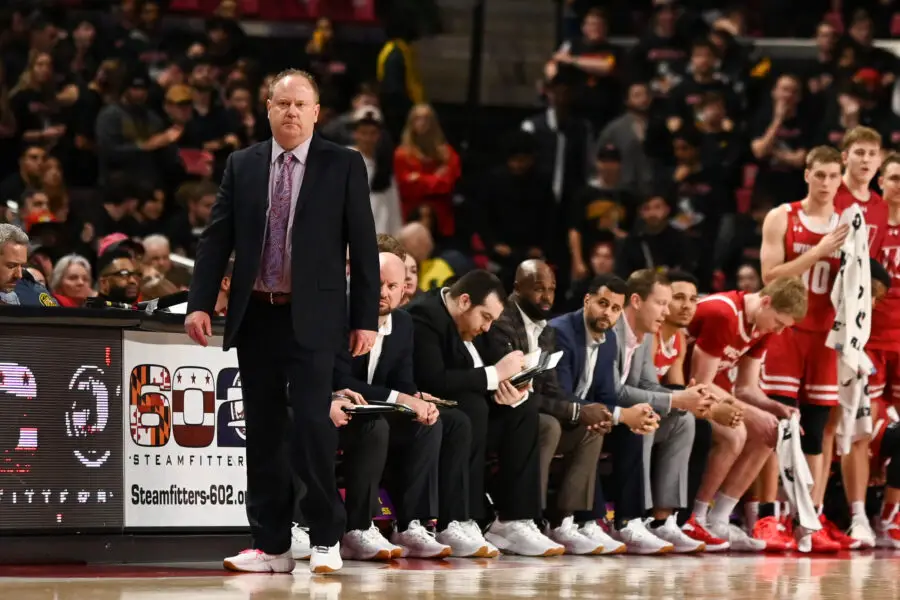Wisconsin basketball head coach Greg Gard stands near his team's bench during a game