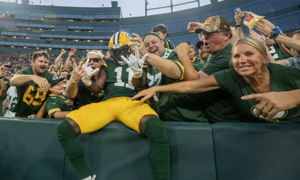 Green Bay Packers wide receiver Jayden Reed celebrates a touchdown with a Lambeau Leap