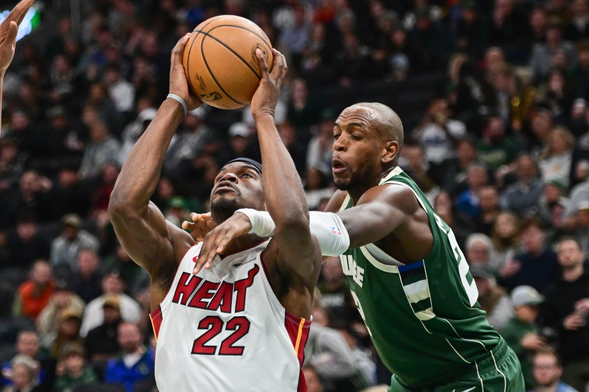 Oct 30, 2023; Milwaukee, Wisconsin, USA; Miami Heat center Jimmy Butler (22) is fouled by Milwaukee Bucks center Khris Middleton (22) in the fourth quarter at Fiserv Forum. Mandatory Credit: Benny Sieu-USA TODAY Sports