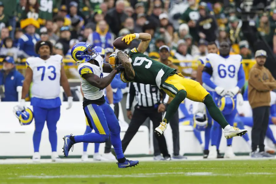 Nov 5, 2023; Green Bay, Wisconsin, USA; Green Bay Packers wide receiver Christian Watson (9) makes a leaping catch in front of Los Angeles Rams defensive back Russ Yeast (2) during the fourth quarter at Lambeau Field. Mandatory Credit: Jeff Hanisch-USA TODAY Sports