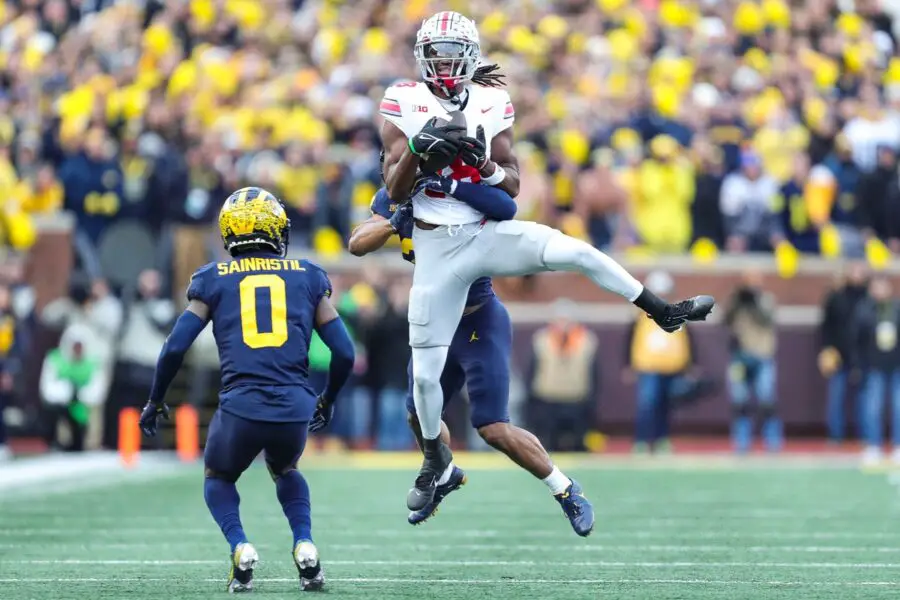 Ohio State wide receiver Marvin Harrison Jr. makes a catch against Michigan defensive backs Quinten Johnson and Mike Sainristil during the second half at Michigan Stadium in Ann Arbor on Saturday, Nov. 25, 2023. © Junfu Han / USA TODAY NETWORK