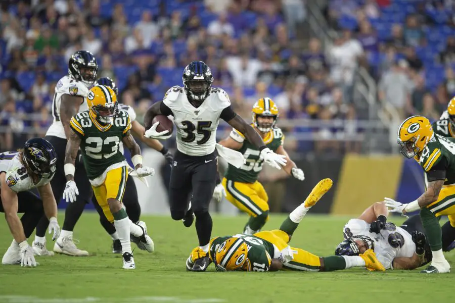 Aug 15, 2019; Baltimore, MD, USA; Baltimore Ravens running back Gus Edwards (35) breaks Green Bay Packers strong safety Adrian Amos (31) arm tackle during the first quarter as cornerback Jaire Alexander (23) defends at M&T Bank Stadium. Mandatory Credit: Tommy Gilligan-USA TODAY Sports