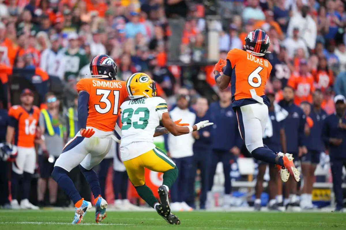 Oct 22, 2023; Denver, Colorado, USA; Denver Broncos safety P.J. Locke (6) intercepts a ball intended for Green Bay Packers wide receiver Samori Toure (83) as safety Justin Simmons (31) defends in the fourth quarter at Empower Field at Mile High. Mandatory Credit: Ron Chenoy-USA TODAY Sports
