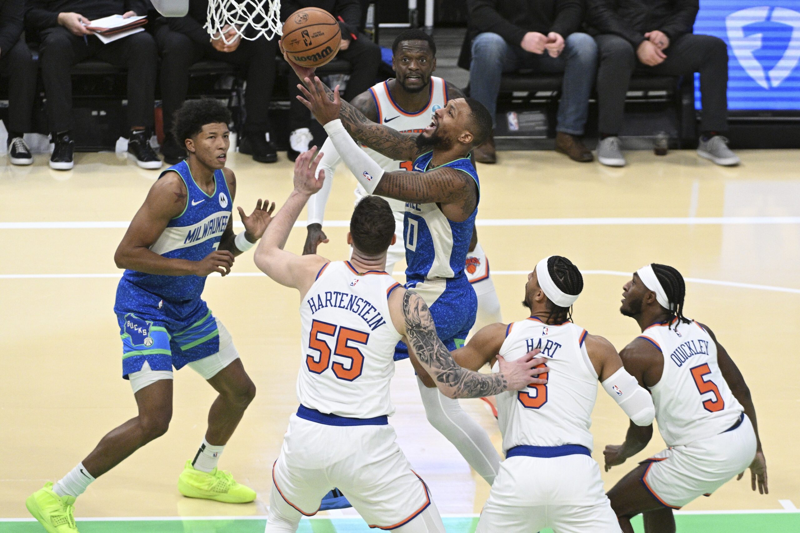 Dec 5, 2023; Milwaukee, Wisconsin, USA; Milwaukee Bucks guard Damian Lillard (0) drives to the basket against New York Knicks defenders in the second half at Fiserv Forum. Mandatory Credit: Michael McLoone-USA TODAY Sports