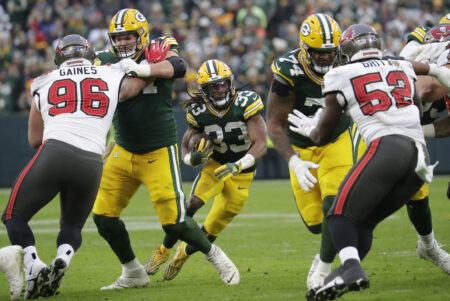 Dec 17, 2023; Green Bay, Wisconsin, USA; Green Bay Packers running back Aaron Jones (33) looks for room to run against the Tampa Bay Buccaneers during their football game at Lambeau Field. Mandatory Credit: Dan Powers-USA TODAY Sports