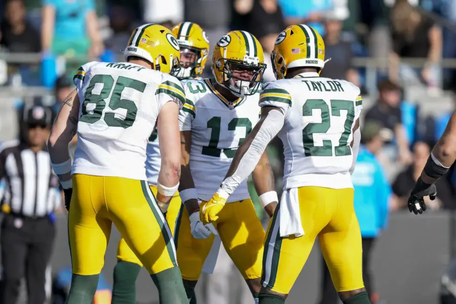 Dec 24, 2023; Charlotte, North Carolina, USA; Green Bay Packers wide receiver Dontayvion Wicks (13) celebrates a touchdown catch with teammates during the second quarter against the Carolina Panthers at Bank of America Stadium. Mandatory Credit: Jim Dedmon-USA TODAY Sports