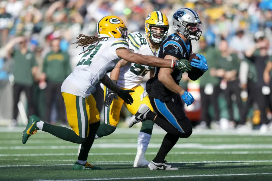 Dec 24, 2023; Charlotte, North Carolina, USA; Carolina Panthers wide receiver Adam Thielen (19) runs for yards after catch chased by Green Bay Packers cornerback Eric Stokes (21) and linebacker Isaiah McDuffie (58) during the second quarter at Bank of America Stadium. Mandatory Credit: Jim Dedmon-USA TODAY Sports