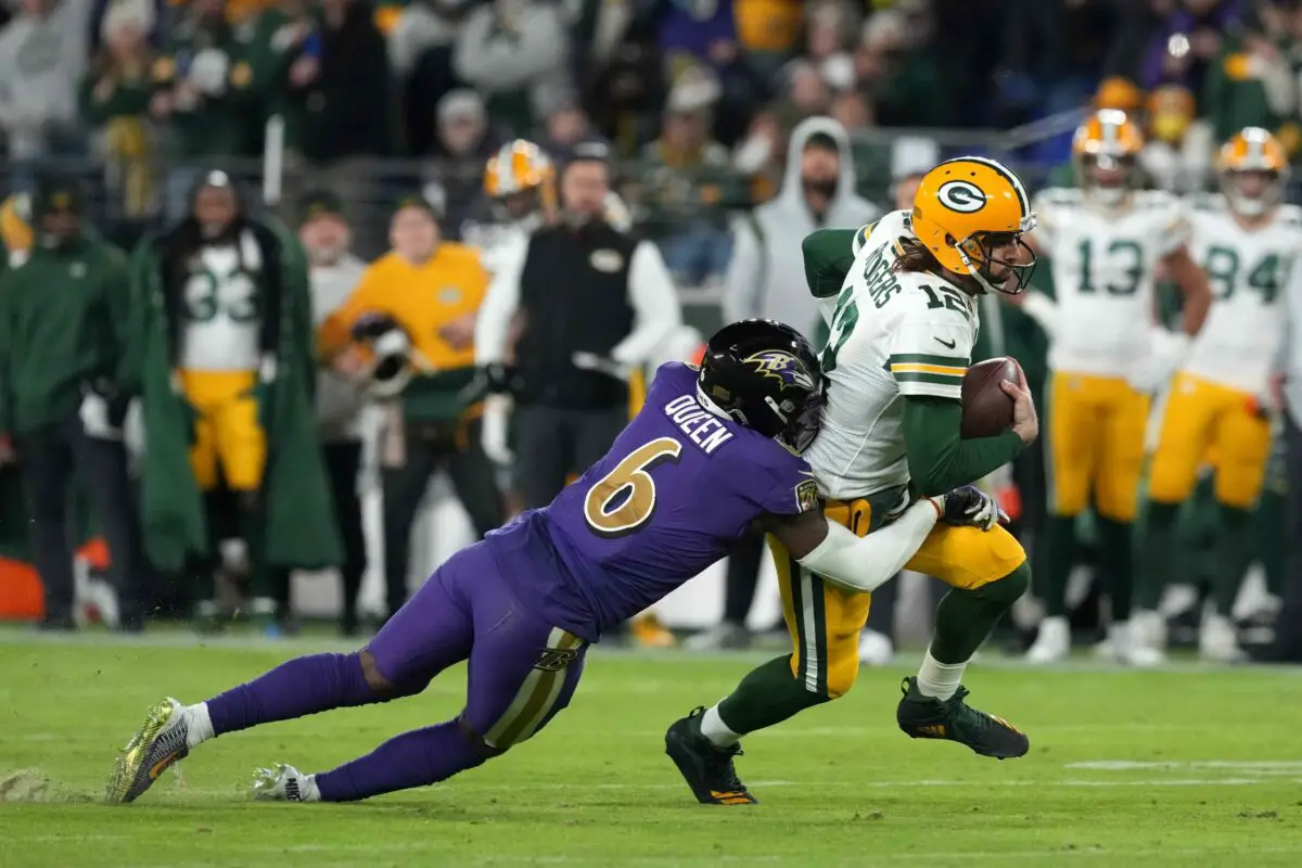 Dec 19, 2021; Baltimore, Maryland, USA; Green Bay Packers quarterback Aaron Rodgers (12) runs the ball in the second quarter while defended by Baltimore Ravens linebacker Patrick Queen (6) at M&T Bank Stadium. Mandatory Credit: Mitch Stringer-USA TODAY Sports