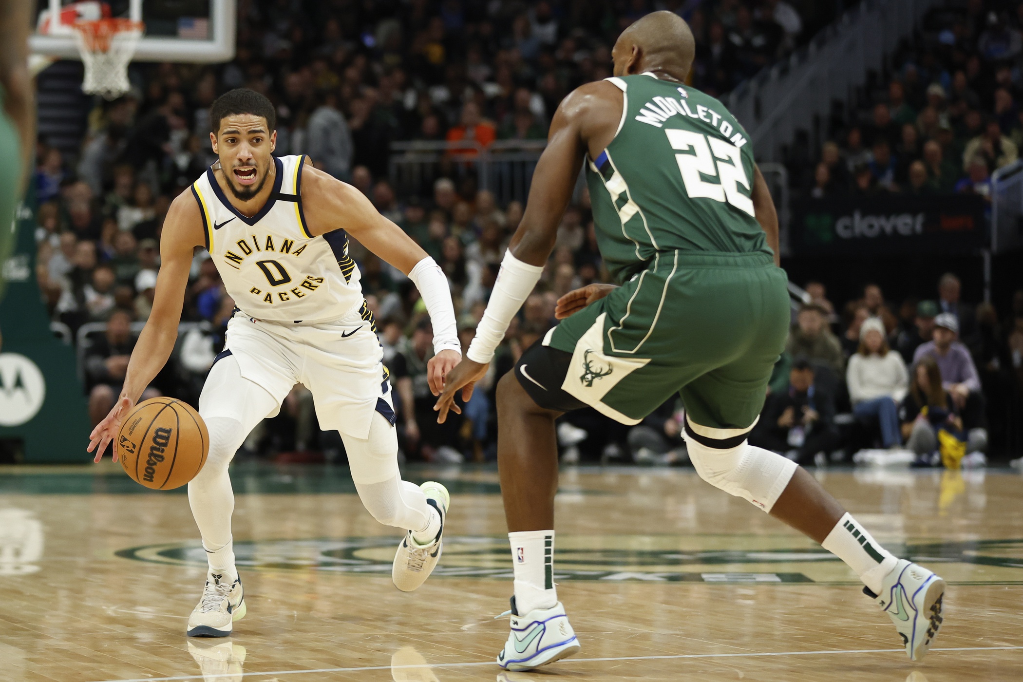 Jan 1, 2024; Milwaukee, Wisconsin, USA; Indiana Pacers guard Tyrese Haliburton (0) brings the ball up court against Milwaukee Bucks forward Khris Middleton (22) during the second half at Fiserv Forum. Mandatory Credit: Kamil Krzaczynski-USA TODAY Sports