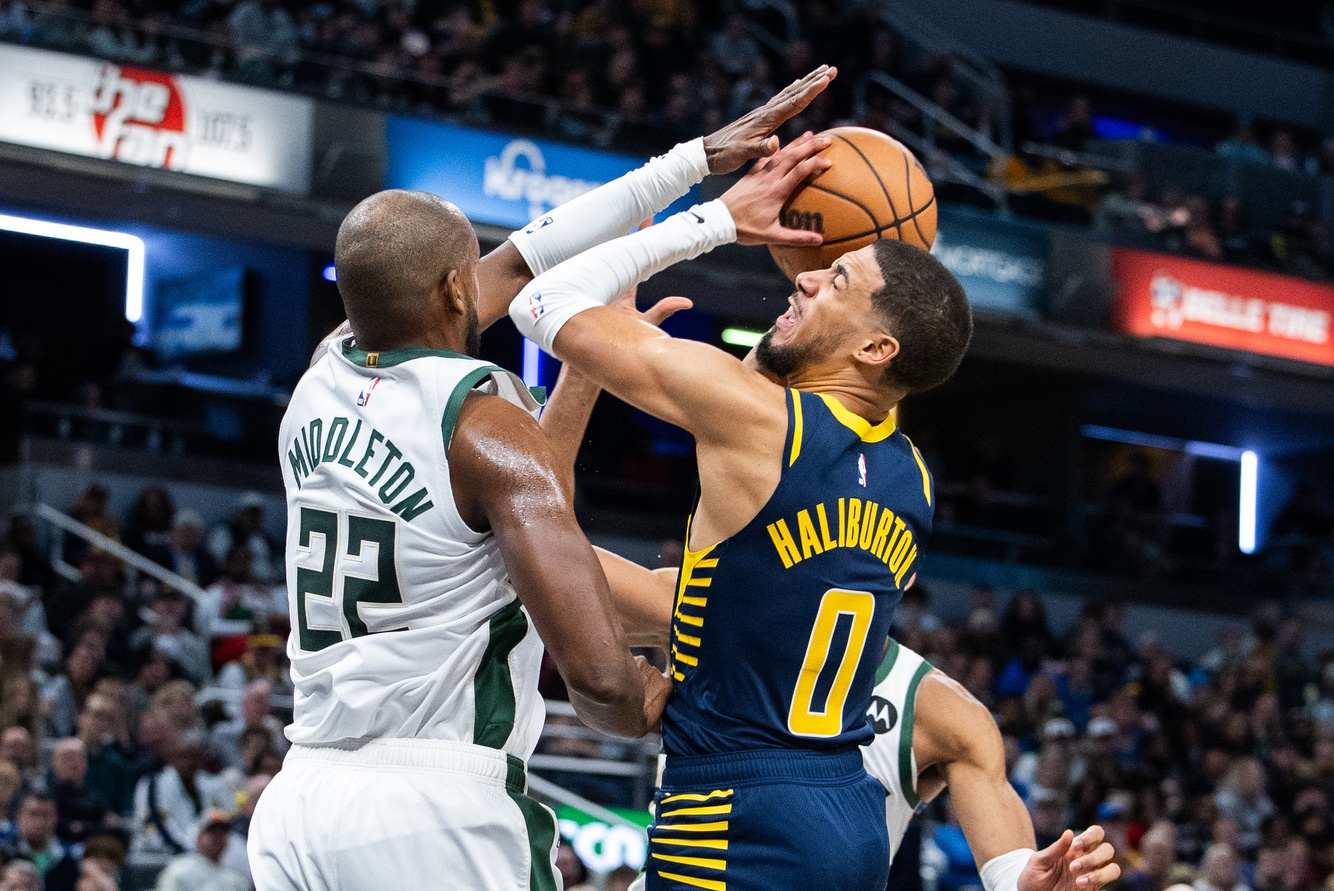 Jan 3, 2024; Indianapolis, Indiana, USA; Indiana Pacers guard Tyrese Haliburton (0) shoots the ball while Milwaukee Bucks forward Khris Middleton (22) defends in the second half at Gainbridge Fieldhouse. Mandatory Credit: Trevor Ruszkowski-USA TODAY Sports