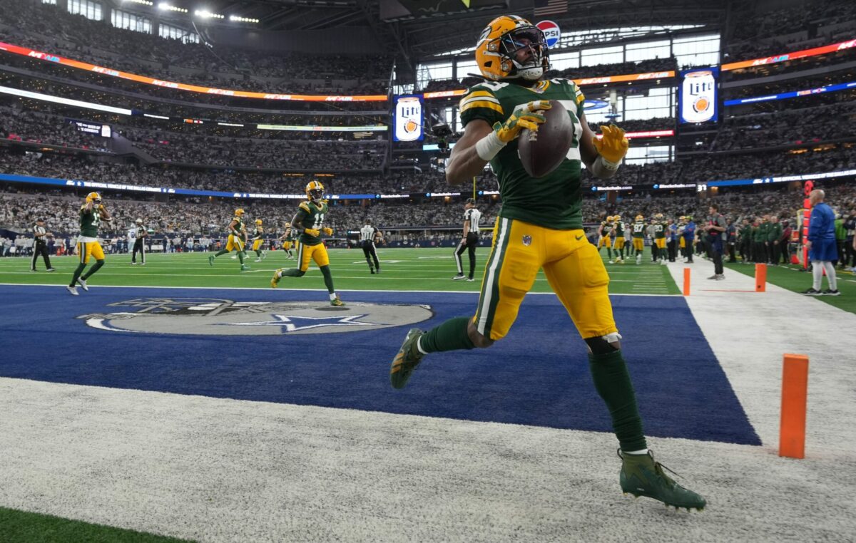 Green Bay Packers running back Aaron Jones (33) toss the ball in the stands after scoring a touchdown during the first quarter of the wild card playoff game against the Dallas Cowboys Sunday, January 14, 2024 at AT&T Stadium in Arlington, Texas.
