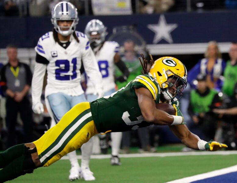 Green Bay Packers running back Aaron Jones (33) dives for his third touchdown of the day against the Dallas Cowboys during the third quarter of their wild card playoff game Sunday, January 14, 2024 at AT&T Stadium in Arlington, Texas.