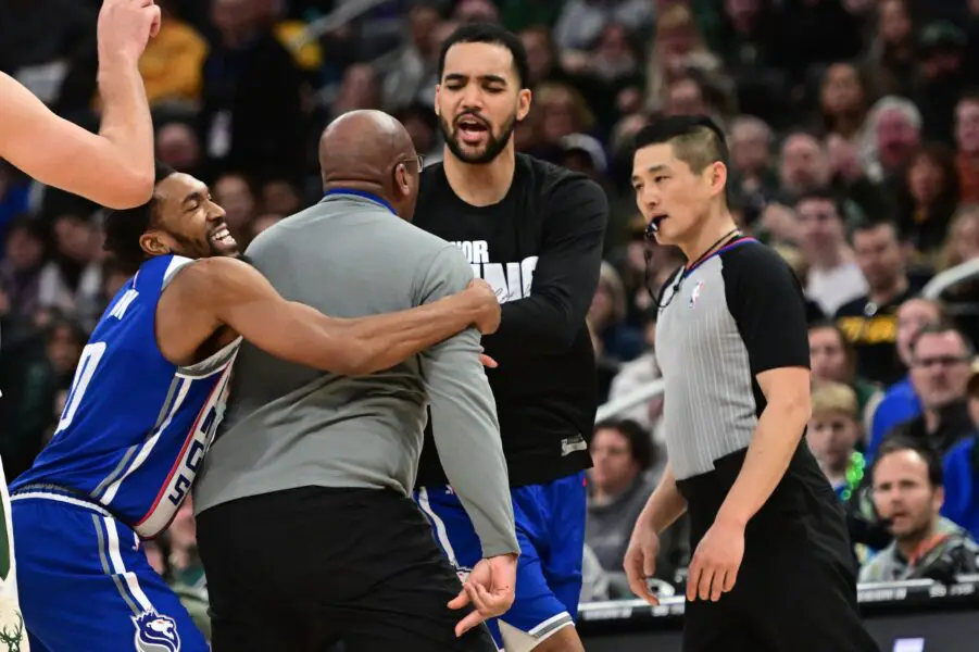 Jan 14, 2024; Milwaukee, Wisconsin, USA; Sacramento Kings head coach Mike Brown is restrained by guard Malik Monk (0) as he argues with referee Intae Hwang in the fourth quarter at Fiserv Forum. Mandatory Credit: Benny Sieu-USA TODAY Sports