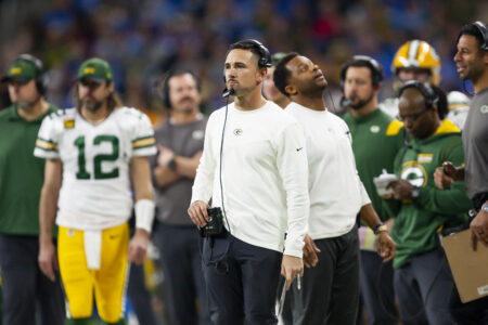 Jan 9, 2022; Detroit, Michigan, USA; Green Bay Packers head coach Matt LaFleur looks on with quarterback Aaron Rodgers (12) in the background during the fourth quarter against the Detroit Lions at Ford Field. Mandatory Credit: Raj Mehta-USA TODAY Sports