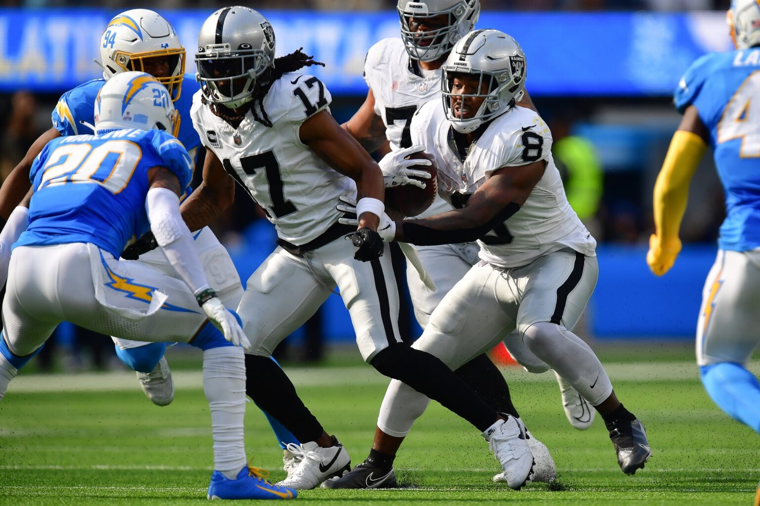 Oct 1, 2023; Inglewood, California, USA; Las Vegas Raiders running back Josh Jacobs (8) runs the ball as wide receiver Davante Adams (17) provides coverage against Los Angeles Chargers safety Dean Marlowe (20) during the second half at SoFi Stadium. Mandatory Credit: Gary A. Vasquez-USA TODAY Sports