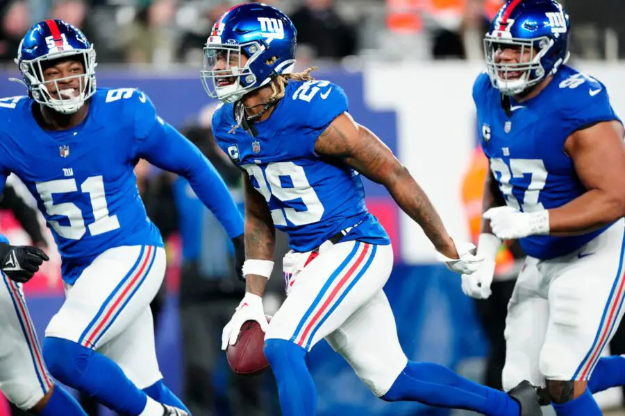 New York Giants safety Xavier McKinney (29) holds the ball as he celebrates with New York Giants linebacker Azeez Ojulari (51) and New York Giants defensive tackle Dexter Lawrence II (97) after he intercepted a Philadelphia Eagles pass, Sunday, January 7, 2024.