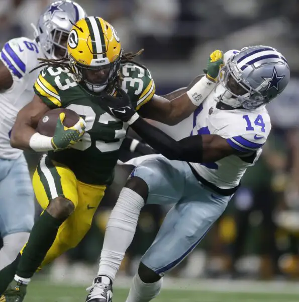 Jan 14, 2024; Arlington, Texas, USA; Green Bay Packers running back Aaron Jones (33) rushes against Dallas Cowboys safety Markquese Bell (14) during the first quarter of their wild card playoff game Sunday, January 14, 2024 at AT&T Stadium in Arlington, Texas. Mandatory Credit: Wm. Glasheen-USA TODAY Sports