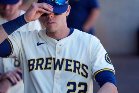 Mar 1, 2024; Phoenix, Arizona, USA; Milwaukee Brewers outfielder Christian Yelich (22) readies himself in the dugout during a spring training game against the San Diego Padres at American Family Fields of Phoenix. Mandatory Credit: Allan Henry-USA TODAY Sports