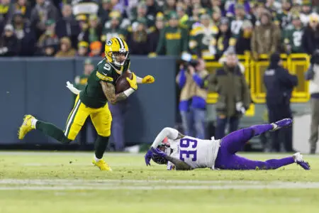 Jan 1, 2023; Green Bay, Wisconsin, USA; Green Bay Packers wide receiver Christian Watson (9) rushes with the football after catching a pass in front of Minnesota Vikings cornerback Chandon Sullivan (39) during the third quarter at Lambeau Field. Mandatory Credit: Jeff Hanisch-USA TODAY Sports