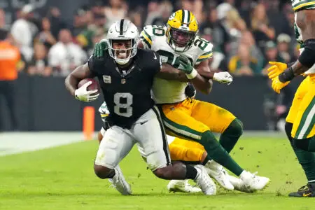 Oct 9, 2023; Paradise, Nevada, USA; Green Bay Packers safety Rudy Ford (20) tackles Las Vegas Raiders running back Josh Jacobs (8) during the third quarter at Allegiant Stadium. Mandatory Credit: Stephen R. Sylvanie-USA TODAY Sports
