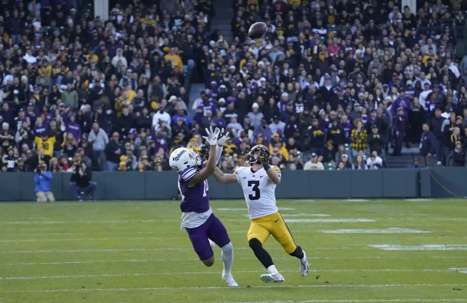 Nov 4, 2023; Chicago, Illinois, USA; Northwestern Wildcats wide receiver Cam Johnson (14) tries to catch a pass as Iowa Hawkeyes defensive back Cooper DeJean (3) defends during the first half at Wrigley Field. Mandatory Credit: David Banks-USA TODAY Sports