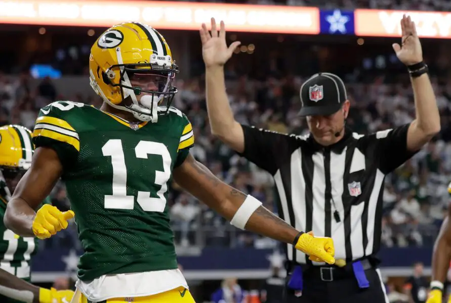 Green Bay Packers wide receiver Dontayvion Wicks (13) celebrates after catching a touchdown pass against Dallas Cowboys linebacker Micah Parsons (11) during the second quarter of their wild card playoff game Sunday, January 14, 2024 at AT&T Stadium in Arlington, Texas.
