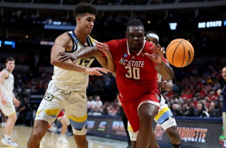 Mar 29, 2024; Dallas, TX, USA; Marquette Golden Eagles forward Oso Ighodaro (13) and North Carolina State Wolfpack forward DJ Burns Jr. (30) chase a loose ball during the first half in the semifinals of the South Regional of the 2024 NCAA Tournament at American Airlines Center. Mandatory Credit: Tim Heitman-USA TODAY Sports