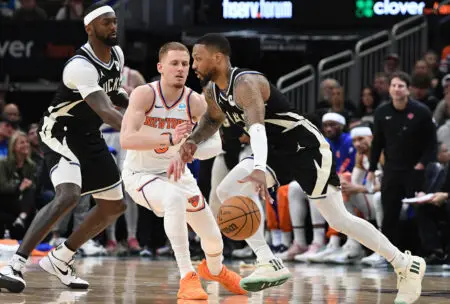 Apr 7, 2024; Milwaukee, Wisconsin, USA; Milwaukee Bucks guard Damian Lillard (0) drives against New York Knicks guard Donte DiVincenzo (0) in the second half at Fiserv Forum. Mandatory Credit: Michael McLoone-USA TODAY Sports