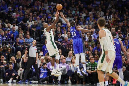 Apr 14, 2024; Orlando, Florida, USA; Milwaukee Bucks forward Khris Middleton (22) shoots the ball against Orlando Magic center Wendell Carter Jr. (34) during the second half at KIA Center. Mandatory Credit: Mike Watters-USA TODAY Sports