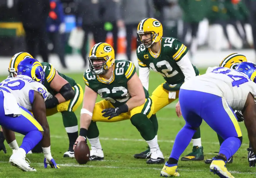 Jan 16, 2021; Green Bay, Wisconsin, USA; Green Bay Packers center Corey Linsley (63) prepares to snap the ball to quarterback Aaron Rodgers (12) against the Los Angeles Rams during the NFC Divisional Round at Lambeau Field. Mandatory Credit: Mark J. Rebilas-USA TODAY Sports