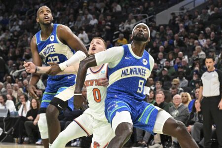 Dec 5, 2023; Milwaukee, Wisconsin, USA; Milwaukee Bucks forward Bobby Portis (9) blocks New York Knicks guard Donte DiVincenzo (0) during the second half of a game at Fiserv Forum. Mandatory Credit: Michael McLoone-USA TODAY Sports