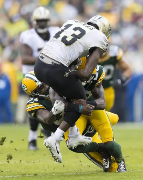Oct 22, 2017; Green Bay, WI, USA; Green Bay Packers safety Kentrell Brice (29) and cornerback Davon House (31) tackle New Orleans Saints wide receiver Michael Thomas (13) during the third quarter at Lambeau Field. Mandatory Credit: Jeff Hanisch-USA TODAY Sports