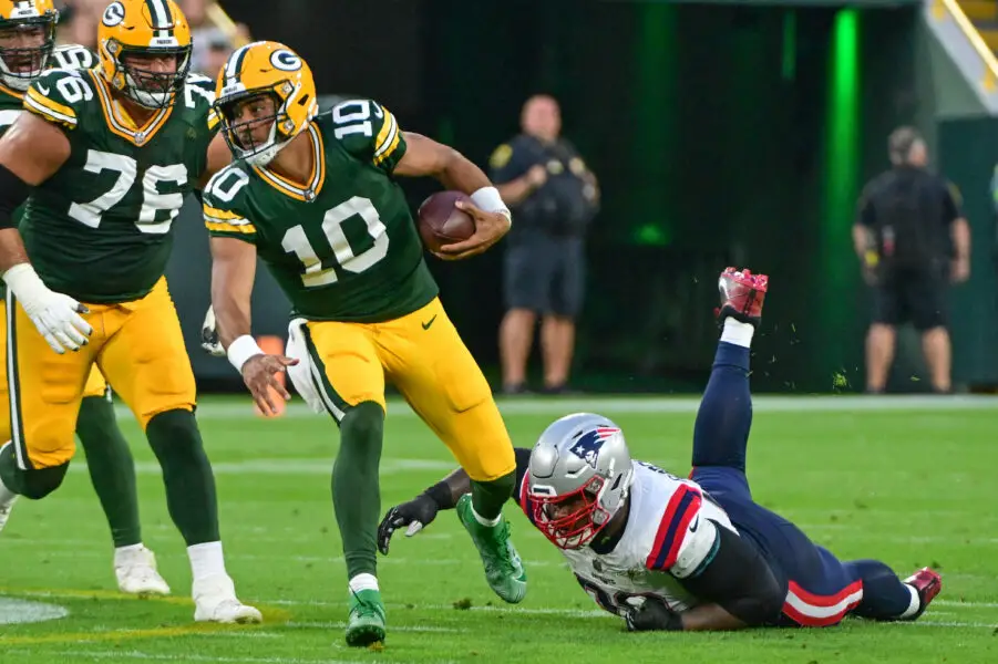 Aug 19, 2023; Green Bay, Wisconsin, USA; Green Bay Packers quarterback Jordan Love (10) breaks a tackle by New England Patriots defensive tackle Davon Godchaux (92) in the first quarter at Lambeau Field. Mandatory Credit: Benny Sieu-USA TODAY Sports