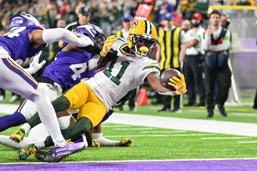 Dec 31, 2023; Minneapolis, Minnesota, USA; Green Bay Packers wide receiver Jayden Reed (11) scores a touchdown as Minnesota Vikings safety Josh Metellus and safety Camryn Bynum (24) attempt to make the tackle during the second quarter at U.S. Bank Stadium. Mandatory Credit: Jeffrey Becker-USA TODAY Sports