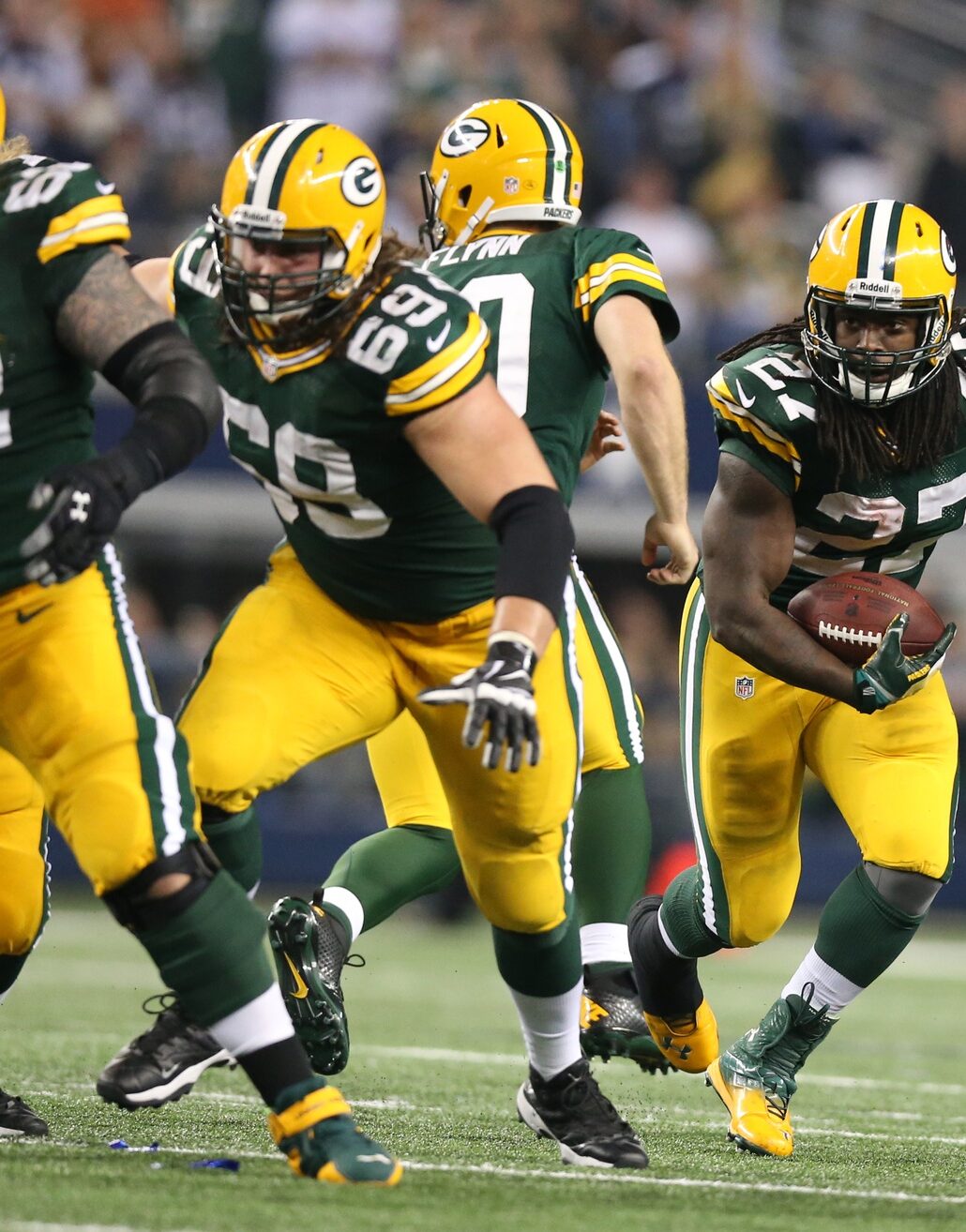 Dec 15, 2013; Arlington, TX, USA; Green Bay Packers running back Eddie Lacy (27) runs with the ball with lead blocking provided by tackle David Bakhtiari (69) and center Evan Dietrich-Smith (62) against the Dallas Cowboys at AT&T Stadium. Mandatory Credit: Matthew Emmons-USA TODAY Sports