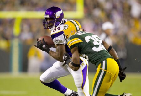 Oct 24, 2010; Green Bay, WI, USA; Minnesota Vikings wide receiver Randy Moss (84) rushes with the football after catching a pass as Green Bay Packers cornerback Tramon Williams (right) defends during the second quarter at Lambeau Field. Mandatory Credit: Jeff Hanisch-USA TODAY Sports