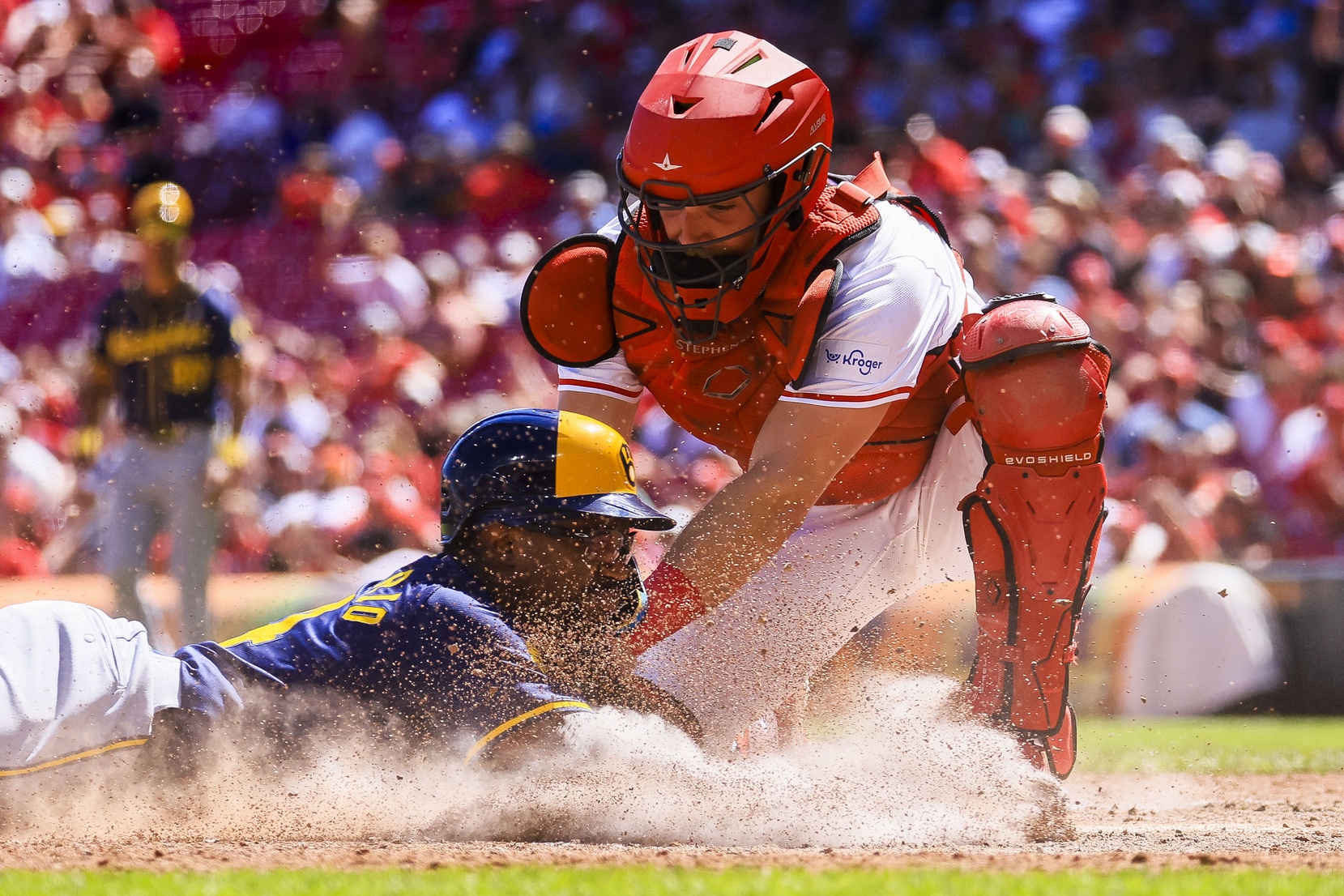 Cincinnati Reds catcher Tyler Stephenson (37) tags Milwaukee Brewers pinch runner Andruw Monasterio (14) out at home plate in the tenth inning at Great American Ball Park.