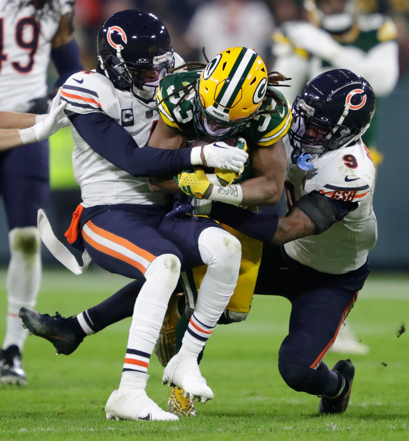 Green Bay Packers running back Aaron Jones (33) runs for a first down against Chicago Bears safety Eddie Jackson (4) and safety Jaquan Brisker (9) during their football game Sunday, January 7, 2024, in Green Bay, Wisconsin.© Dan Powers/USA TODAY NETWORK-Wisconsin / USA TODAY NETWORK