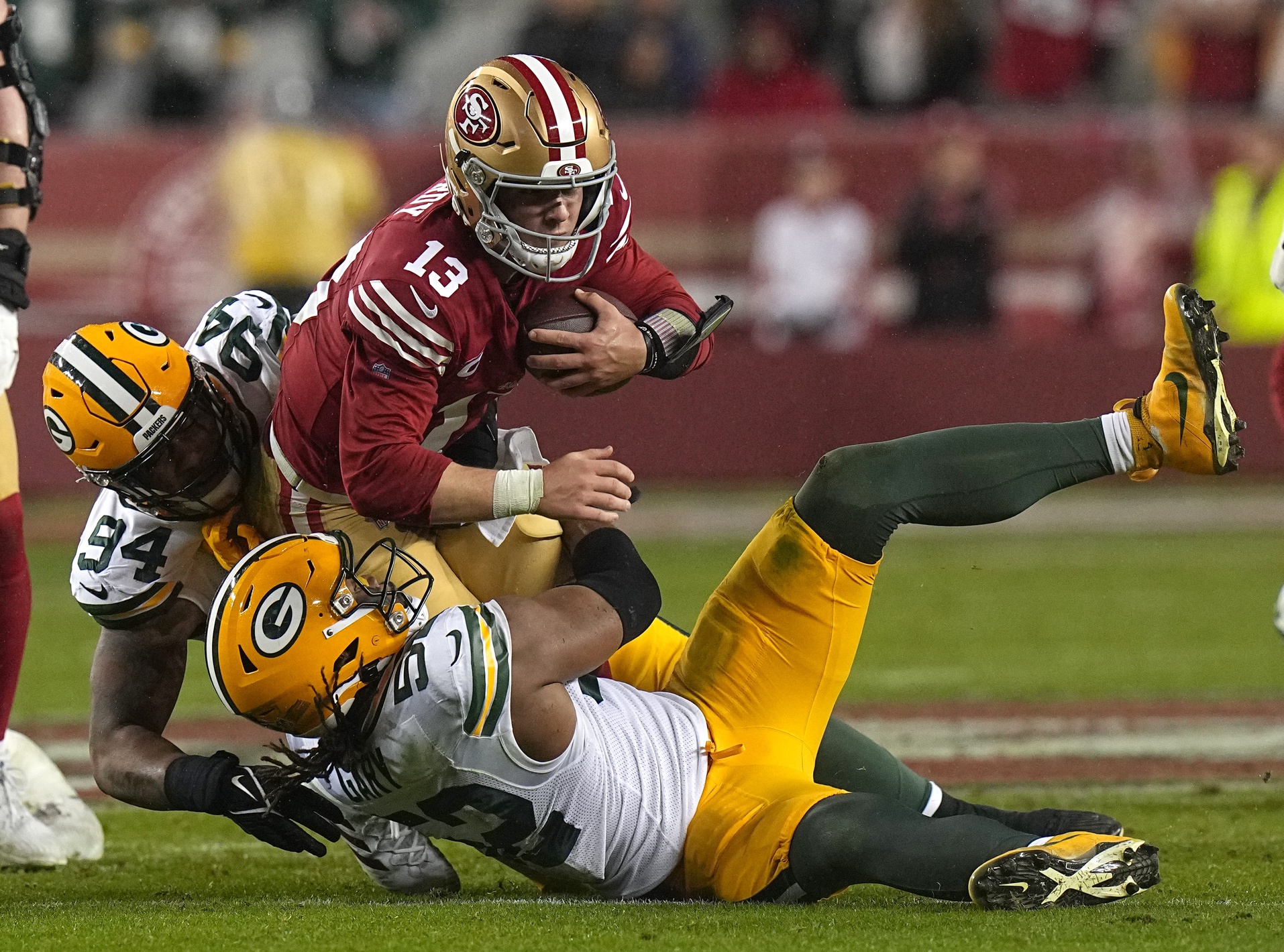 San Francisco 49ers quarterback Brock Purdy (13) is tackled by Green Bay Packers defensive end Karl Brooks (94) and Rashan Gary (52) after a one yard gain during the third quarter of their NFC divisional playoff game Saturday, January 20, 2024 at Levi’ Stadium in Santa Clara, California. The San Francisco 49ers beat the Green Bay Packers 24-21. © Mark Hoffman / Milwaukee Journal Sentinel / USA TODAY NETWORK