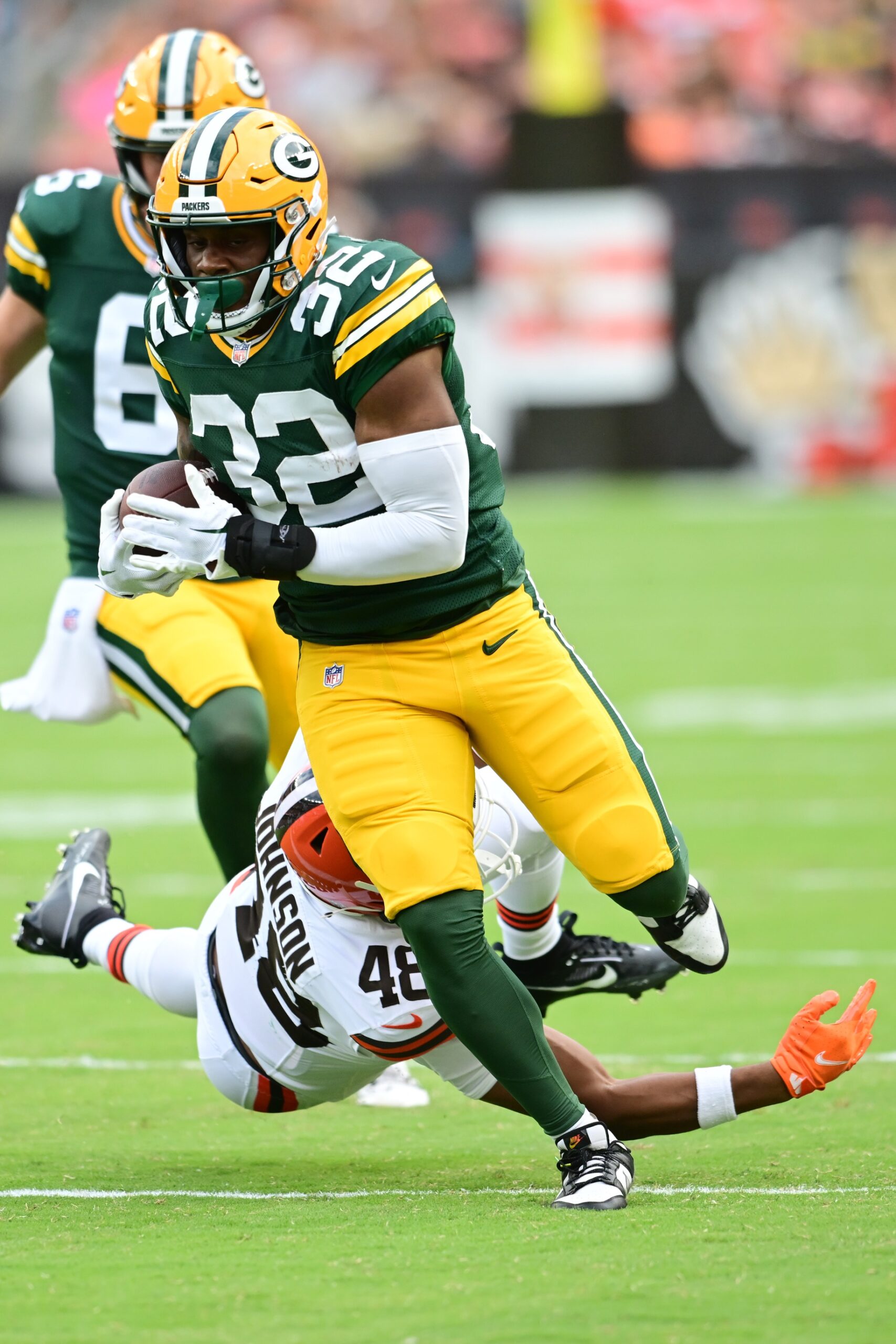 Aug 10, 2024; Cleveland, Ohio, USA; Green Bay Packers running back MarShawn Lloyd (32) runs with the ball as Cleveland Browns linebacker Caleb Johnson (48) defends during the second half at Cleveland Browns Stadium. Mandatory Credit: Ken Blaze-USA TODAY Sports