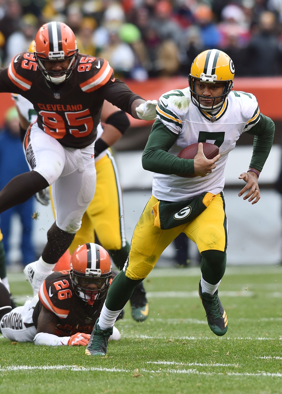 Dec 10, 2017; Cleveland, OH, USA; Green Bay Packers quarterback Brett Hundley (7) runs withe ball away from Cleveland Browns defensive end Myles Garrett (95) and strong safety Derrick Kindred (26) during the second half at FirstEnergy Stadium. Mandatory Credit: Ken Blaze-Imagn Images