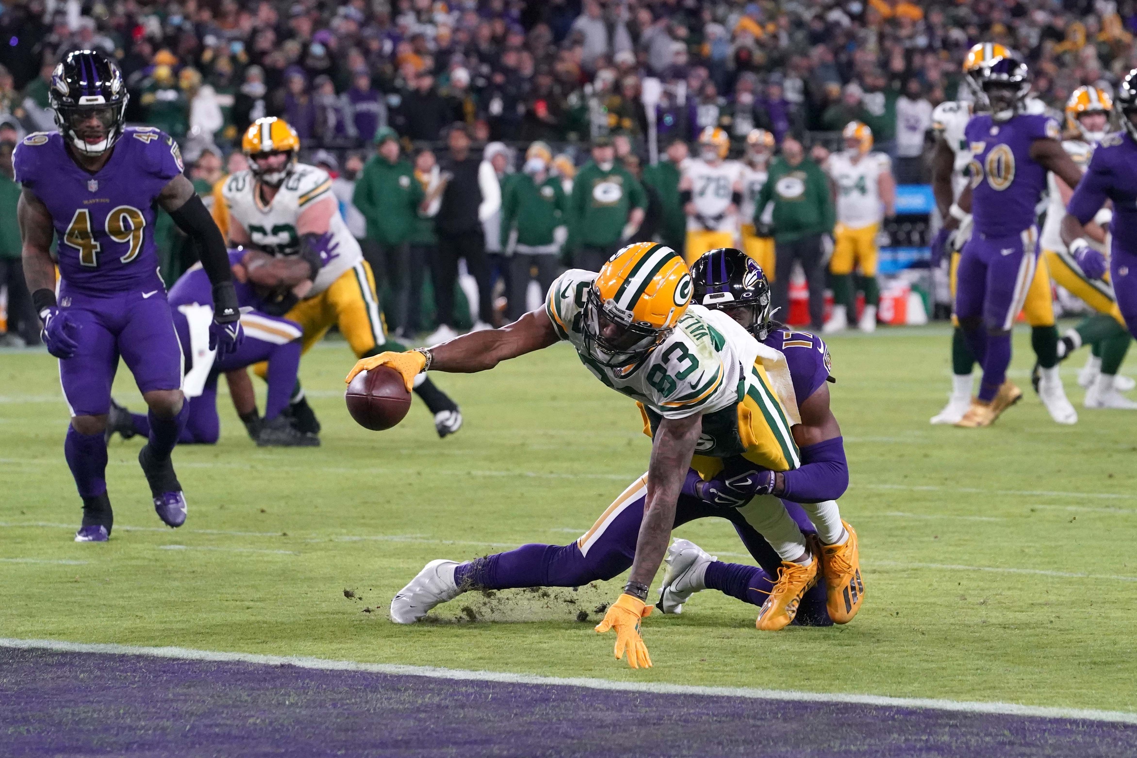 Dec 19, 2021; Baltimore, Maryland, USA; Green Bay Packers wide receiver Marquez Valdez-Scantling (83) reaches the ball across the goal line for a touchdown defended by Baltimore Ravens cornerback Robert Jackson (17) during the fourth quarter at M&T Bank Stadium. Mandatory Credit: Mitch Stringer-Imagn Images