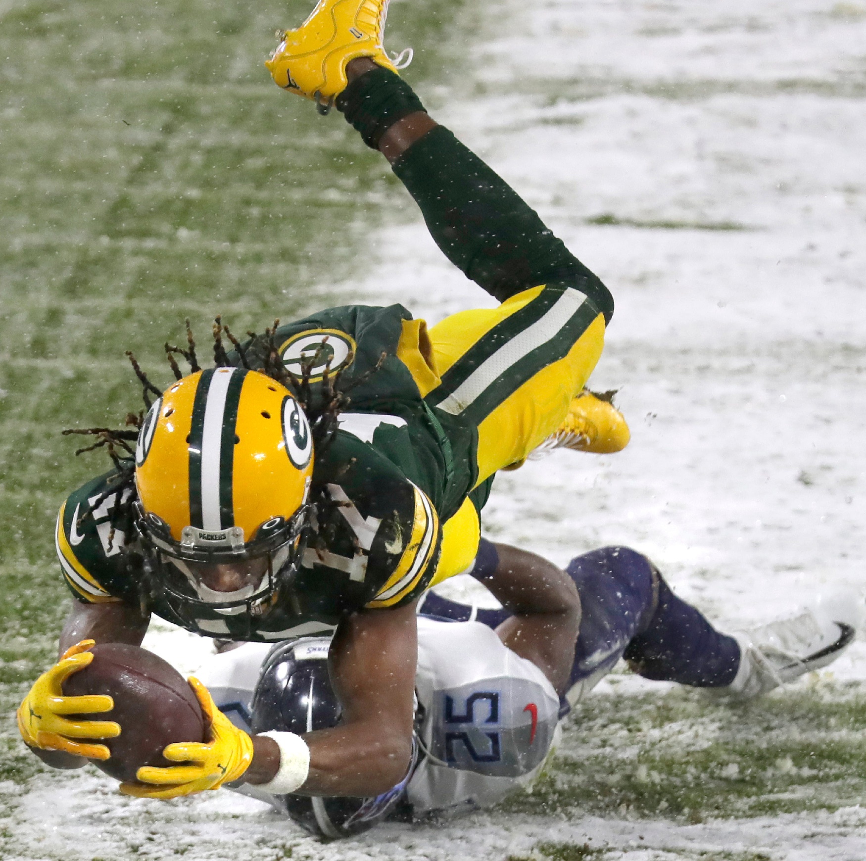 Green Bay Packers wide receiver Davante Adams (17) dives to the end zone over the defense of Tennessee Titans cornerback Adoree' Jackson (25) during the Packers' opening drive on December 27, 2020, at Lambeau Field in Green Bay, Wis. © Wm. Glasheen/USA TODAY NETWORK-Wisconsin / USA TODAY NETWORK via Imagn Images