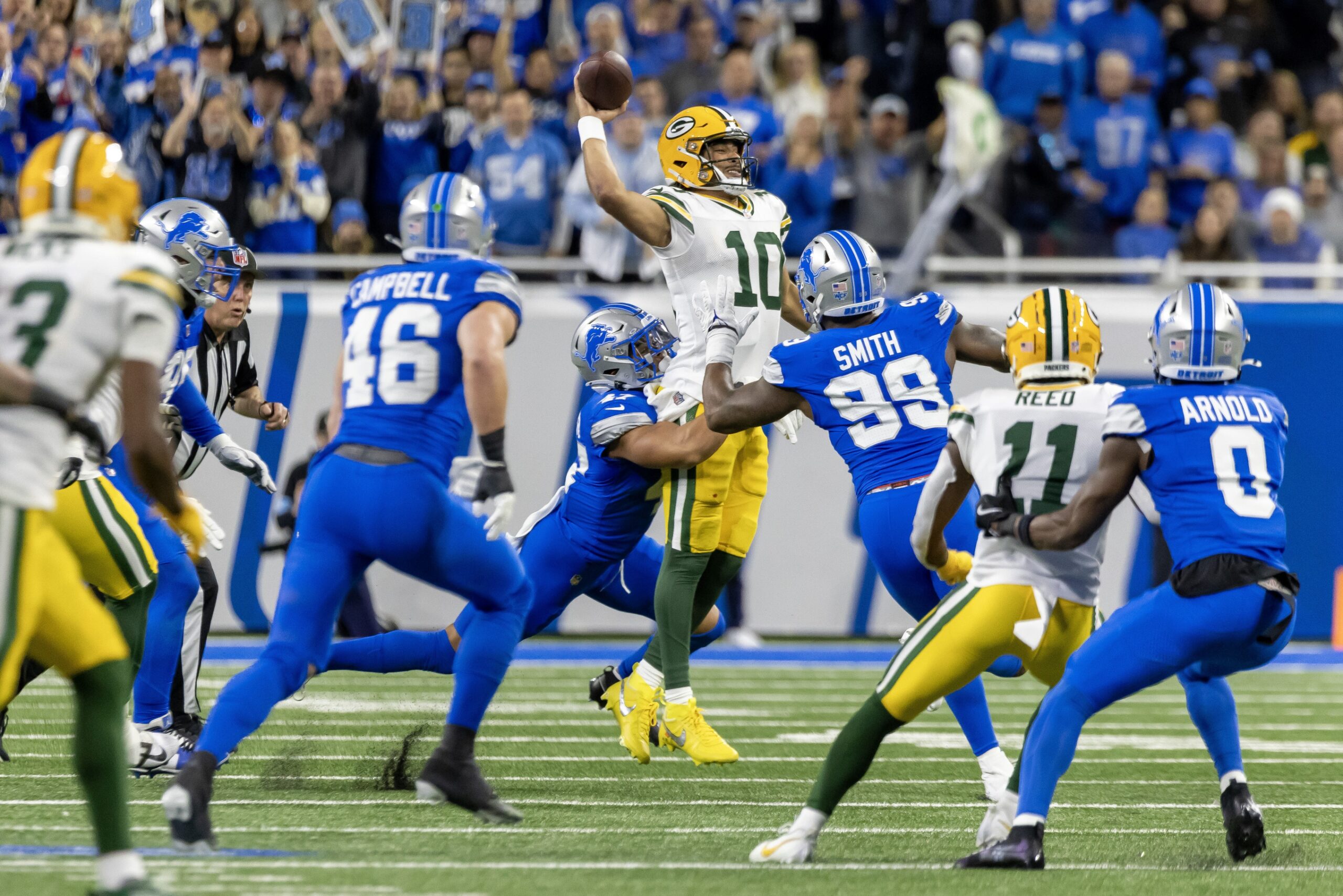 Dec 5, 2024; Detroit, Michigan, USA; Green Bay Packers quarterback Jordan Love (10) is pressured by Detroit Lions linebacker Ezekiel Turner (47) and defensive end Za'Darius Smith (99) during the first half at Ford Field. Mandatory Credit: David Reginek-Imagn Images