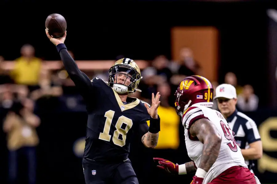 Dec 15, 2024; New Orleans, Louisiana, USA; New Orleans Saints quarterback Spencer Rattler (18) scrambles against Washington Commanders defensive tackle Daron Payne (94) during the second half at Caesars Superdome. Mandatory Credit: Stephen Lew-Imagn Images