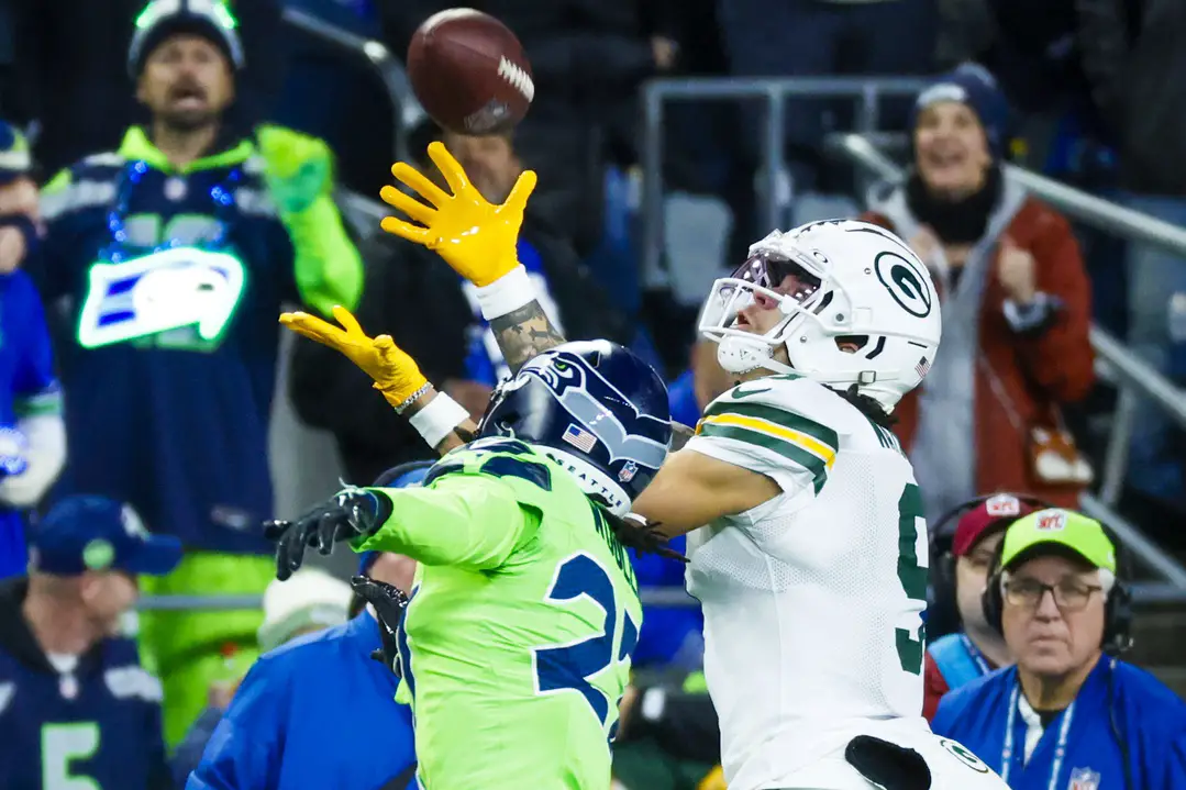 Dec 15, 2024; Seattle, Washington, USA; Green Bay Packers wide receiver Christian Watson (9) catches a pass against Seattle Seahawks cornerback Riq Woolen (27) during the second quarter at Lumen Field. Mandatory Credit: Joe Nicholson-Imagn Images