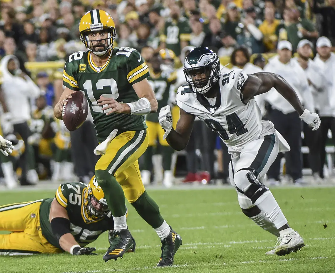 Sep 26, 2019; Green Bay, WI, USA; Green Bay Packers quarterback Aaron Rodgers (12) looks to pass while under pressure from Philadelphia Eagles defensive end Josh Sweat (94) in the second quarter at Lambeau Field. Mandatory Credit: Benny Sieu-Imagn Images