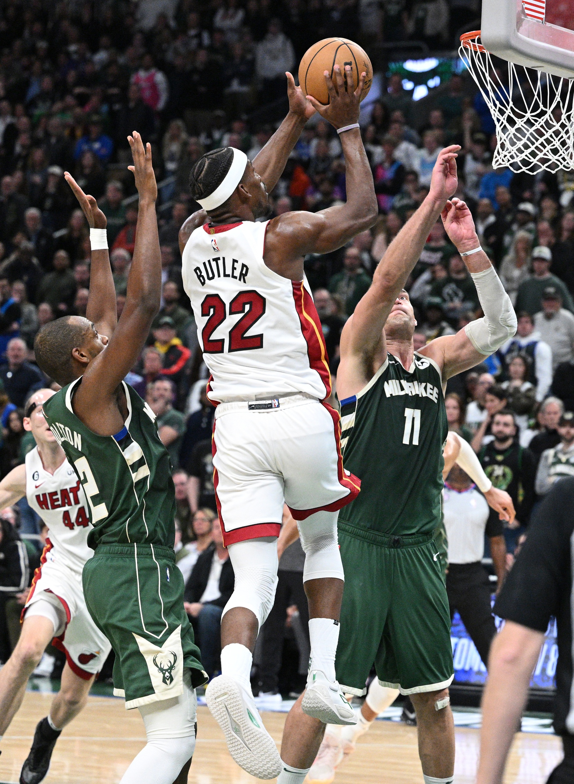 Apr 26, 2023; Milwaukee, Wisconsin, USA; Miami Heat forward Jimmy Butler (22) shoots the ball against Milwaukee Bucks center Brook Lopez (11) during game five of the 2023 NBA Playoffs at Fiserv Forum. Mandatory Credit: Michael McLoone-Imagn Images